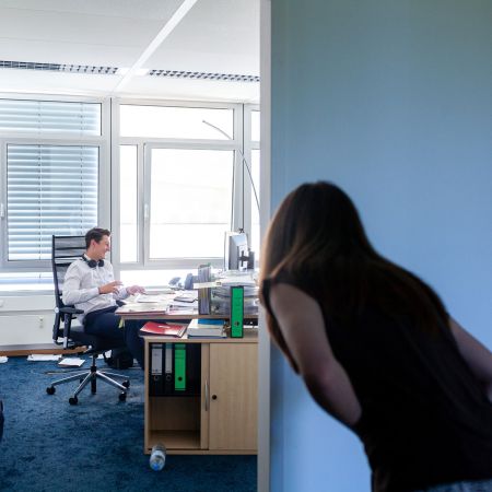 Junger Anwalt mit Kopfhörern am Schreibtisch im Büro bei Plup